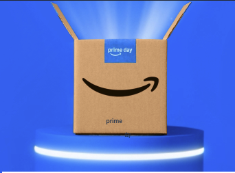 The image shows a cardboard box with the Amazon logo and the words "prime day" on a blue label. The box is open and placed on a blue platform with a glowing edge, set against a blue background with light beams emanating from the box.
